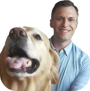 A man smiling next to a happy golden retriever.