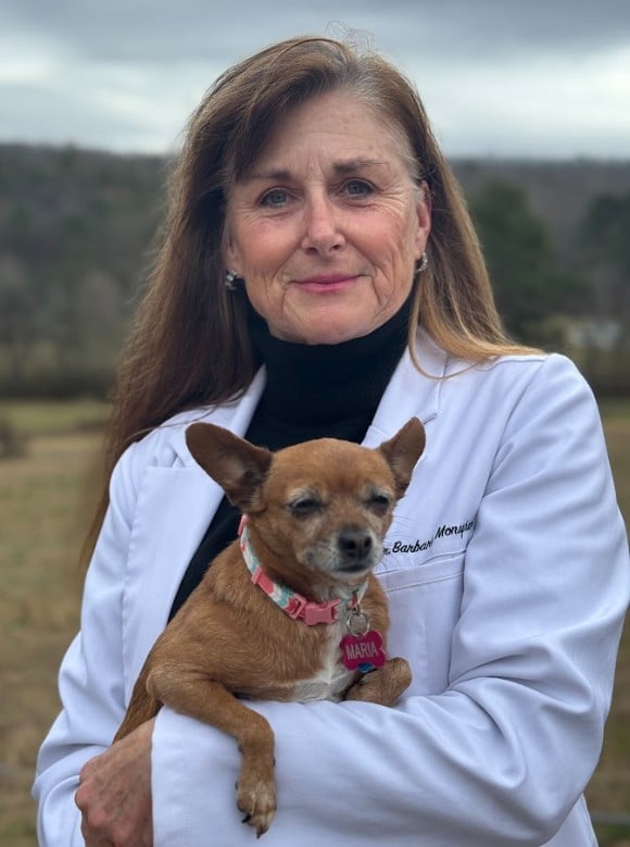 Veterinary clinic owner Dr. Barbara Monaghan holding a dog